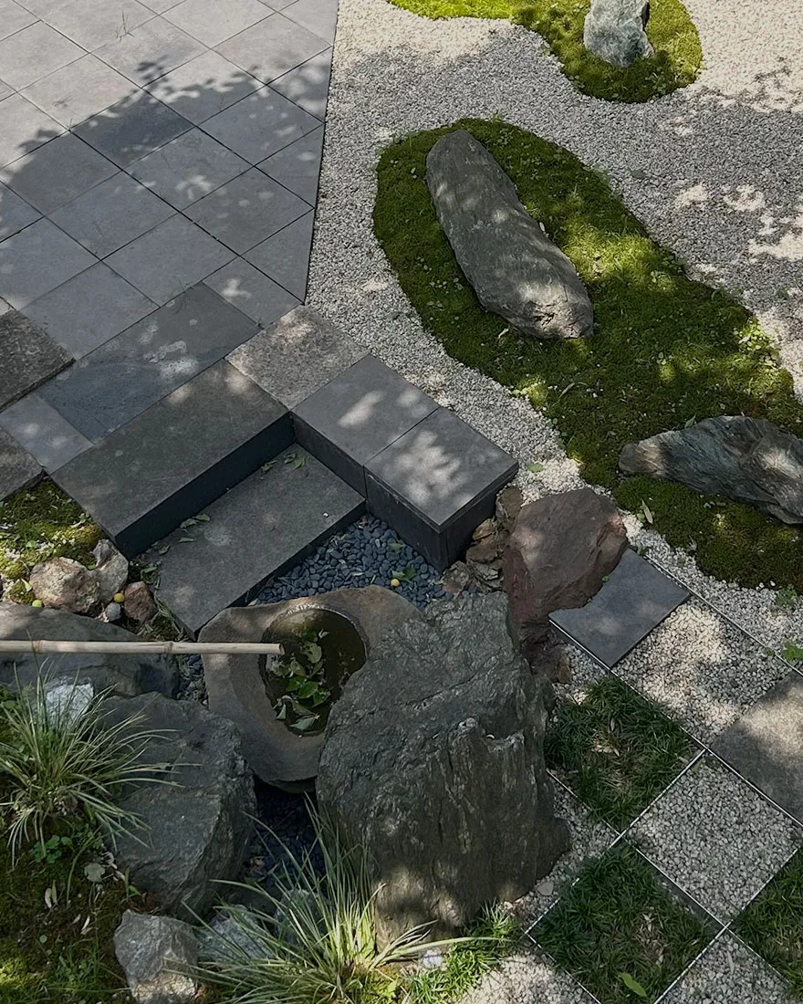 つくばいと景石、砂利と下草による市松模様の敷石を上から見下ろした和風庭園